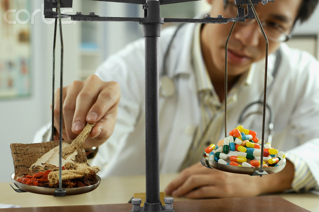 Man Weighing Pills in a Laboratory --- Image by © Simon Marcus/Corbis